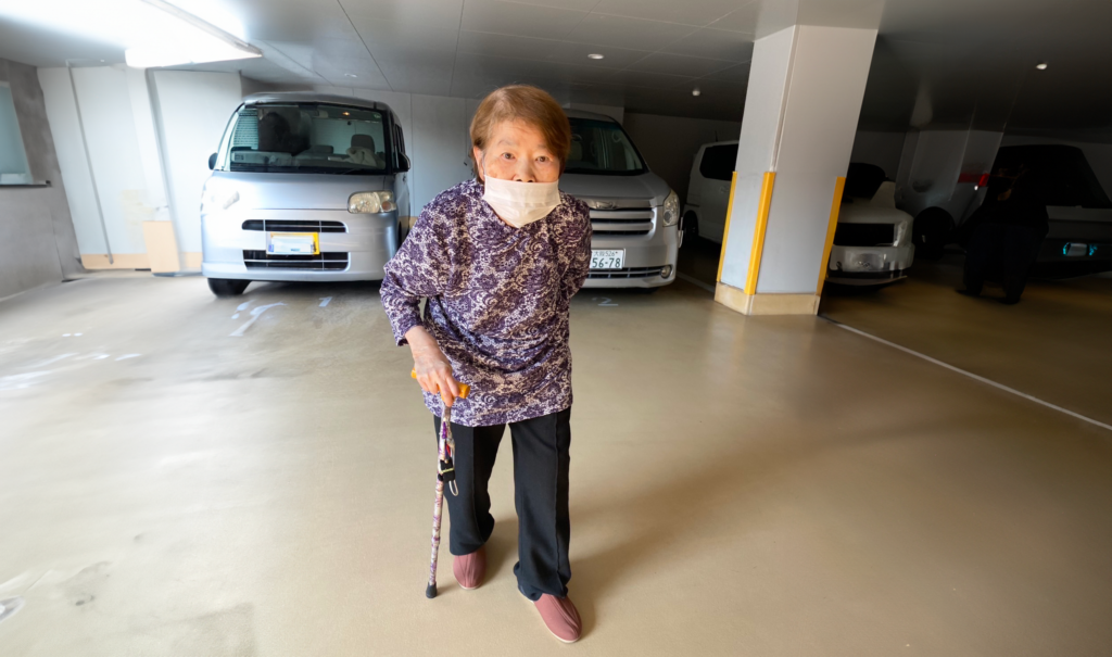 森下フジ子さんが杖を持って歩いている写真